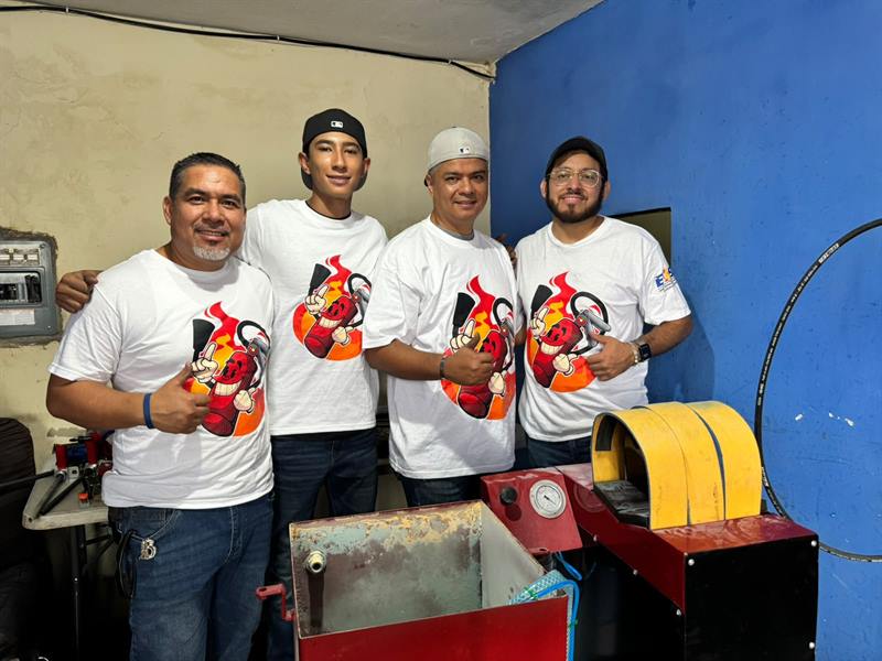 Cuatro técnicos junto a su máquina de recarga recién instalada
