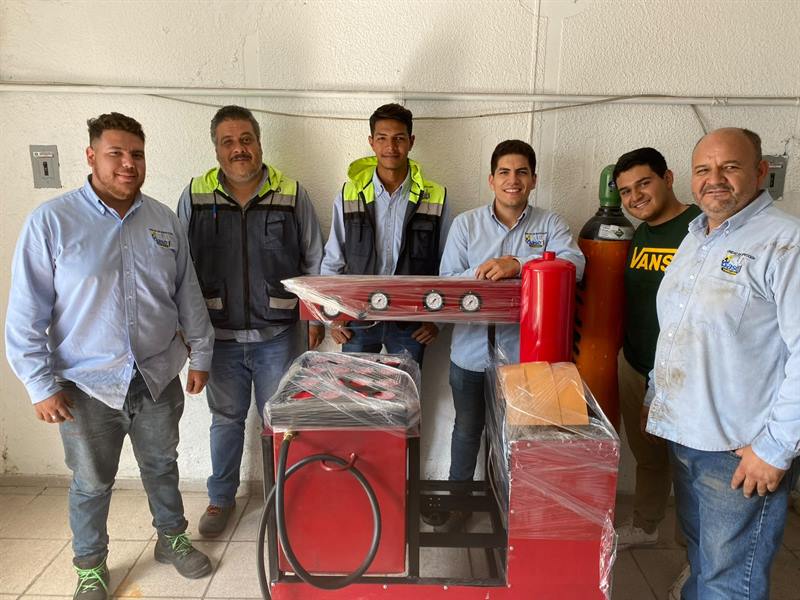 Equipo de seis personas recibiendo su máquina de recarga